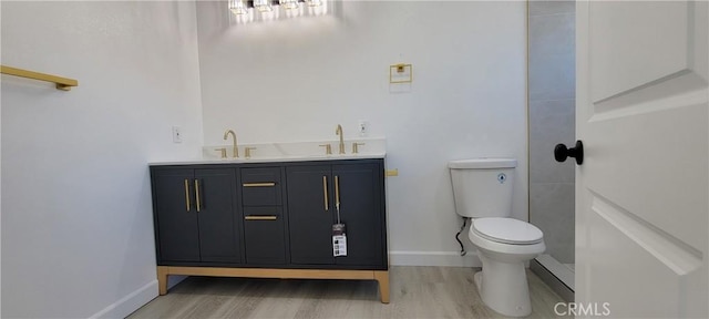 3355 Debbie Ln, Riverside, CA 92501 - bathroom with wood finished floors, toilet, double vanity, and baseboards