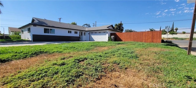3355 Debbie Ln, Riverside, CA 92501 - view of front of home featuring an attached garage, stucco siding, and driveway