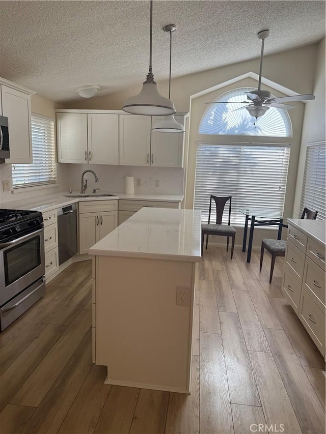 140 W Pioneer Ave Unit 134, Redlands, CA 92374 - kitchen featuring stainless steel appliances, wood-type flooring, a sink, ceiling fan, and a textured ceiling
