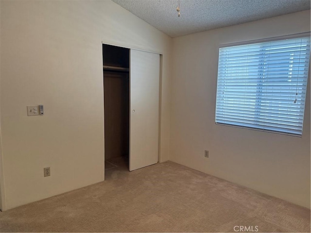 140 W Pioneer Ave Unit 134, Redlands, CA 92374 - unfurnished bedroom with carpet floors, a closet, lofted ceiling, and a textured ceiling