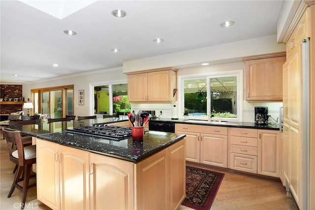4510 Triste Pl, Tarzana, CA 91356 - kitchen featuring light brown cabinets, black appliances, a kitchen bar, a sink, and a kitchen island