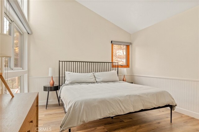 217 Crest Cir, Lake Arrowhead, CA 92352 - bedroom with wainscoting, light wood-style flooring, and high vaulted ceiling