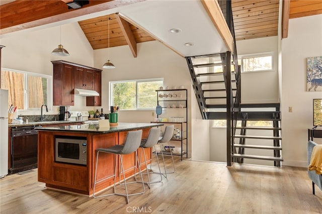 217 Crest Cir, Lake Arrowhead, CA 92352 - kitchen with stainless steel microwave, dishwasher, under cabinet range hood, light wood-style flooring, and wooden ceiling with exposed beams