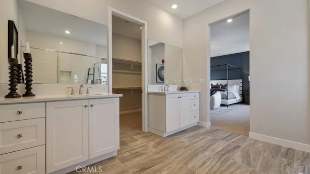 27225 Cranmore Way Unit 302, Valencia, CA 91381 - bathroom featuring two vanities, a stall shower, recessed lighting, baseboards, and a walk in closet