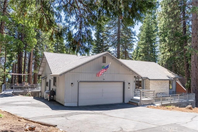 720 E Mountain Ridge Rd, Lake Almanor, CA 96137 - view of side of property with an attached garage, roof with shingles, driveway, and a wooden deck