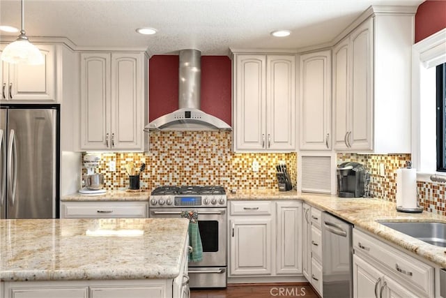 720 E Mountain Ridge Rd, Lake Almanor, CA 96137 - kitchen featuring wall chimney range hood, stainless steel appliances, light stone countertops, pendant lighting, and backsplash