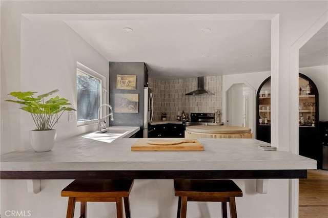 951 Osprey Ln, Lake Arrowhead, CA 92352 - kitchen featuring a sink, wall chimney exhaust hood, light countertops, and a breakfast bar