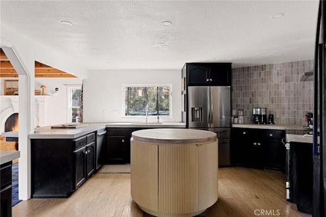 951 Osprey Ln, Lake Arrowhead, CA 92352 - kitchen featuring appliances with stainless steel finishes, light wood-type flooring, dark cabinets, a center island, and light countertops