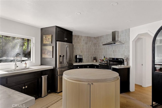 951 Osprey Ln, Lake Arrowhead, CA 92352 - kitchen featuring wall chimney range hood, appliances with stainless steel finishes, a sink, a kitchen island, and light countertops