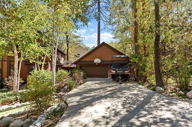 951 Osprey Ln, Lake Arrowhead, CA 92352 - view of front of home with brick siding, an attached garage, and driveway