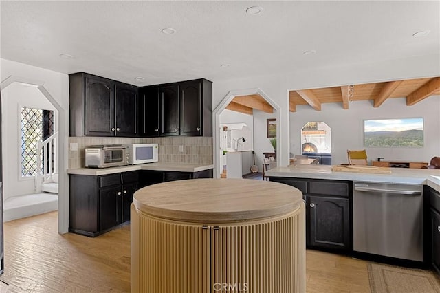 951 Osprey Ln, Lake Arrowhead, CA 92352 - kitchen featuring stainless steel dishwasher, light wood-type flooring, tasteful backsplash, light countertops, and beamed ceiling