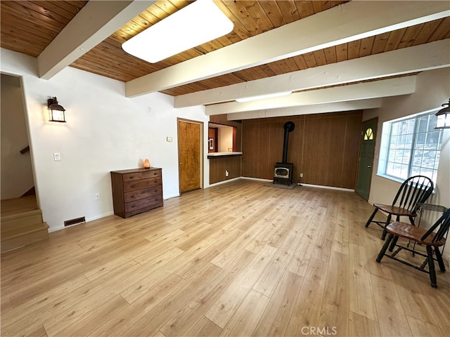 1928 Wilderness Rd, Running Springs, CA 92382 - unfurnished room featuring a wood stove, wooden ceiling with exposed beams, light wood finished floors, stairs, and baseboards