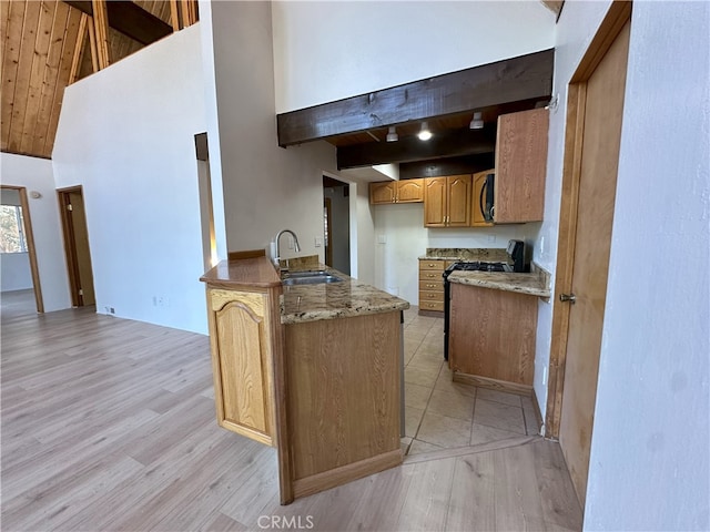 1928 Wilderness Rd, Running Springs, CA 92382 - kitchen with a sink, light wood finished floors, high vaulted ceiling, a peninsula, and beamed ceiling