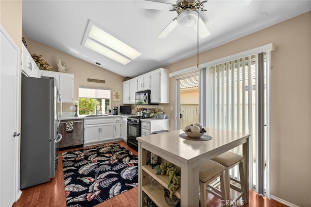 23981 Via Astuto, Murrieta, CA 92562 - kitchen featuring black appliances, wood finished floors, a sink, light countertops, and lofted ceiling