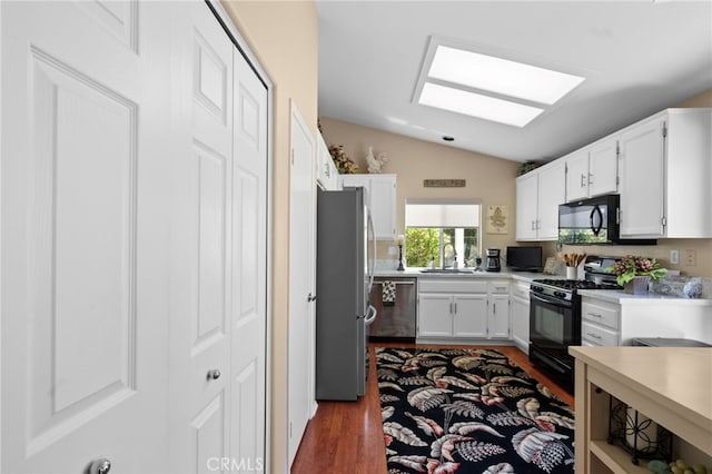 23981 Via Astuto, Murrieta, CA 92562 - kitchen with black appliances, dark wood-type flooring, vaulted ceiling, a sink, and white cabinetry