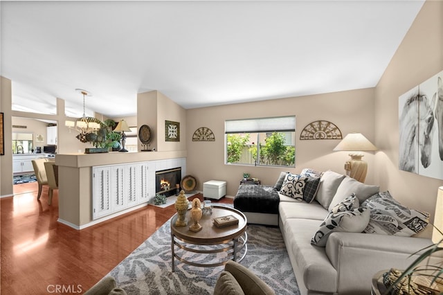 23981 Via Astuto, Murrieta, CA 92562 - living area with wood finished floors, a tiled fireplace, a chandelier, and baseboards