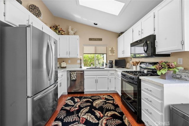 23981 Via Astuto, Murrieta, CA 92562 - kitchen with black appliances, a sink, vaulted ceiling, wood finished floors, and light countertops