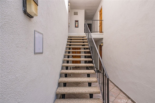 18645 Hatteras St Unit 203, Tarzana, CA 91356 - stairs with a textured wall, tile patterned flooring, and baseboards