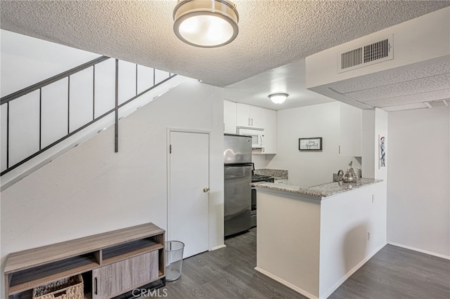 18645 Hatteras St Unit 203, Tarzana, CA 91356 - kitchen featuring stainless steel appliances, dark wood-style floors, white cabinets, a peninsula, and a textured ceiling