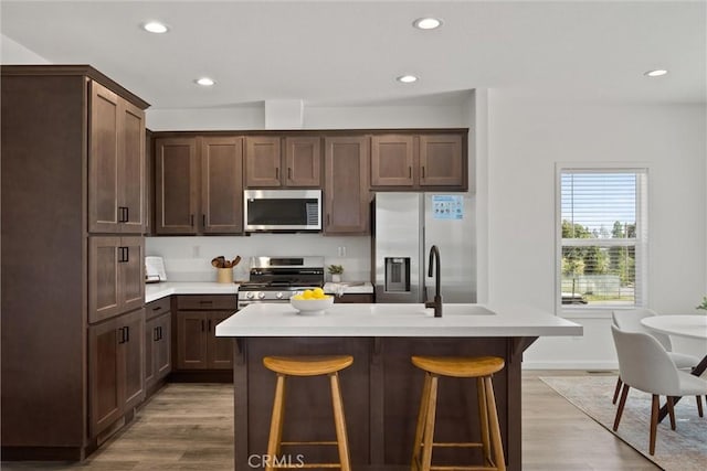 5560 Keith Rd, Paradise, CA 95969 - kitchen with appliances with stainless steel finishes, wood finished floors, light countertops, recessed lighting, and a center island with sink