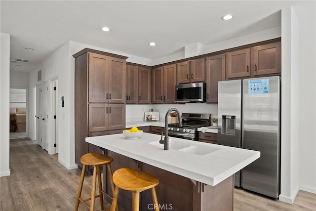 5560 Keith Rd, Paradise, CA 95969 - kitchen with stainless steel appliances, light wood finished floors, baseboards, light countertops, and a breakfast bar