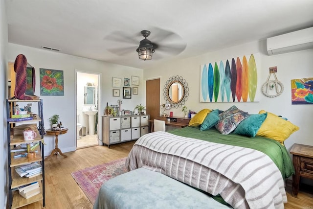 1080 Buena Pl, Carlsbad, CA 92008 - bedroom with a wall mounted AC, wood finished floors, ensuite bathroom, and ceiling fan