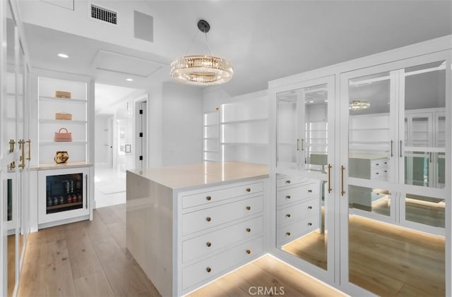 2401 Bayshore Dr, Newport Beach, CA 92663 - walk in closet with light wood-type flooring and a chandelier
