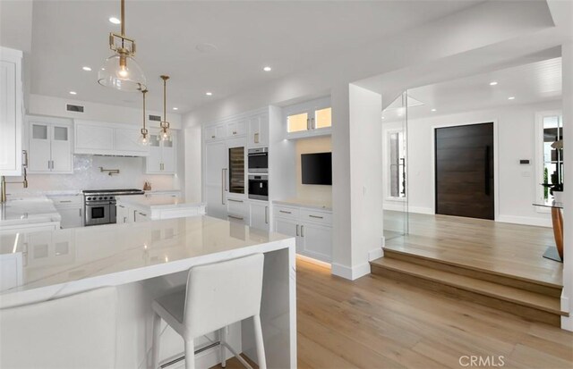 2401 Bayshore Dr, Newport Beach, CA 92663 - kitchen with stainless steel appliances, white cabinets, backsplash, recessed lighting, and light wood finished floors