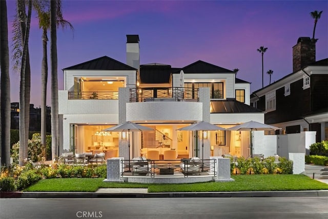 2401 Bayshore Dr, Newport Beach, CA 92663 - back of property at dusk with a balcony, a standing seam roof, and metal roof
