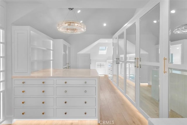 2401 Bayshore Dr, Newport Beach, CA 92663 - walk in closet with lofted ceiling, a chandelier, light wood finished floors, and a skylight