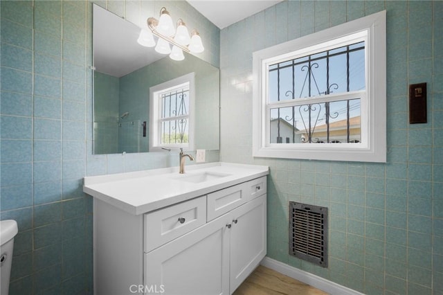 2931 W 137th St, Gardena, CA 90249 - bathroom with tile walls, vanity, toilet, and wood finished floors