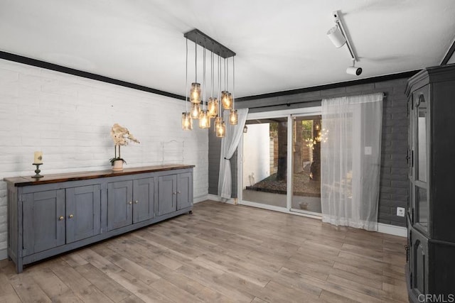 9739 Carta Ln, El Cajon, CA 92021 - unfurnished dining area featuring brick wall, light wood finished floors, baseboards, track lighting, and a chandelier