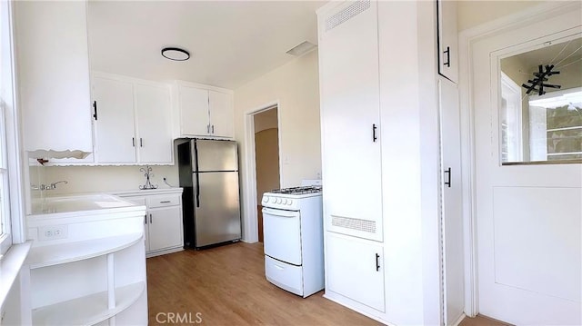 8739 Ralph St, Rosemead, CA 91770 - kitchen featuring freestanding refrigerator, white range with gas stovetop, a sink, white cabinetry, and light countertops