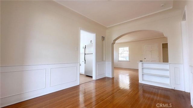 8739 Ralph St, Rosemead, CA 91770 - unfurnished room with arched walkways, crown molding, wood finished floors, wainscoting, and a decorative wall
