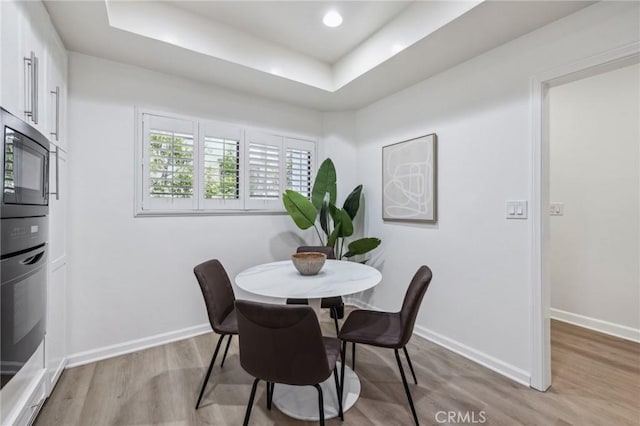 450 San Vicente Blvd Unit 203, Santa Monica, CA 90402 - dining room with light wood-style floors, a raised ceiling, and baseboards