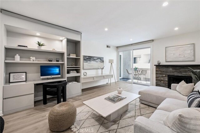 450 San Vicente Blvd Unit 203, Santa Monica, CA 90402 - living area with light wood finished floors, recessed lighting, a stone fireplace, and built in features