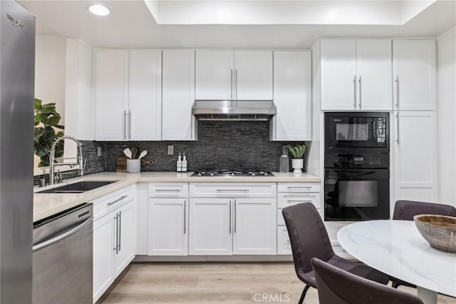 450 San Vicente Blvd Unit 203, Santa Monica, CA 90402 - kitchen featuring black appliances, a sink, under cabinet range hood, light countertops, and recessed lighting