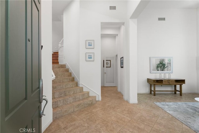 6249 Pacific Pointe Dr Unit 16, Huntington Beach, CA 92648 - foyer entrance with stairway, baseboards, and a towering ceiling