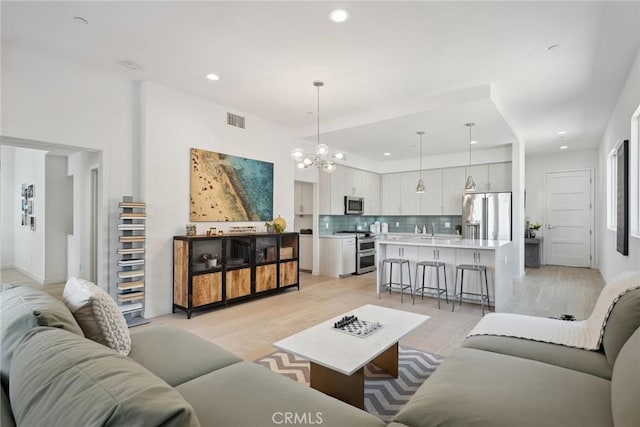 1746 Garfield Pl Unit 203, Los Angeles, CA 90028 - living room with a chandelier, light wood finished floors, and recessed lighting