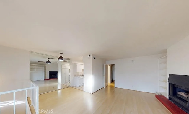 4660 Coldwater Canyon Ave Unit 4, Studio City, CA 91604 - unfurnished living room featuring a fireplace, light wood-type flooring, and a ceiling fan
