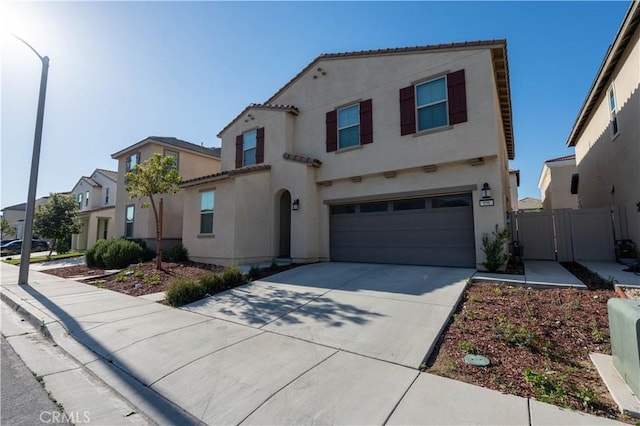 956 W Clover Ave, Rialto, CA 92376 - mediterranean / spanish home with stucco siding, a garage, driveway, a gate, and a tiled roof