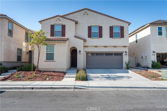 956 W Clover Ave, Rialto, CA 92376 - view of front facade featuring a tiled roof, stucco siding, an attached garage, and driveway