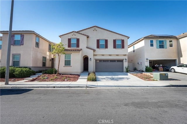 956 W Clover Ave, Rialto, CA 92376 - mediterranean / spanish-style house featuring an attached garage, stucco siding, concrete driveway, and a tiled roof