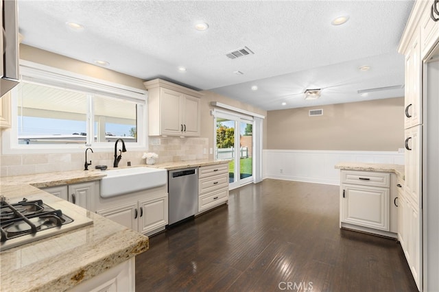 8729 Hillside Rd, Rancho Cucamonga, CA 91701 - kitchen featuring stainless steel appliances, a sink, light stone countertops, a wainscoted wall, and dark wood-style floors