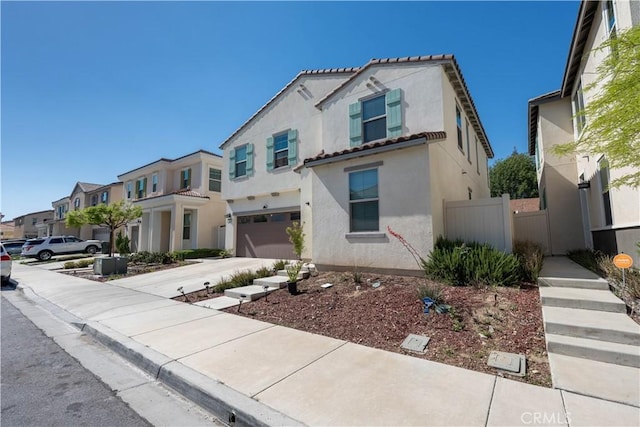 980 W Jasmine Way, Rialto, CA 92376 - mediterranean / spanish-style home featuring an attached garage, a residential view, stucco siding, concrete driveway, and a tile roof
