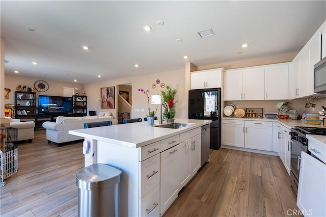 980 W Jasmine Way, Rialto, CA 92376 - kitchen with stainless steel appliances, open floor plan, a sink, light wood-style flooring, and recessed lighting