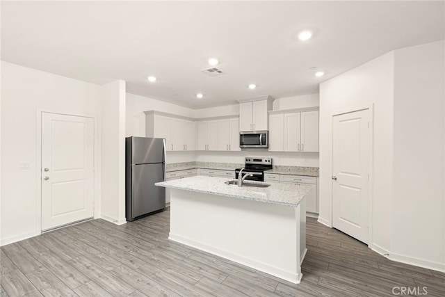 42499 Aruba Ct, Indio, CA 92201 - kitchen with appliances with stainless steel finishes, a sink, a center island with sink, light wood-style floors, and recessed lighting