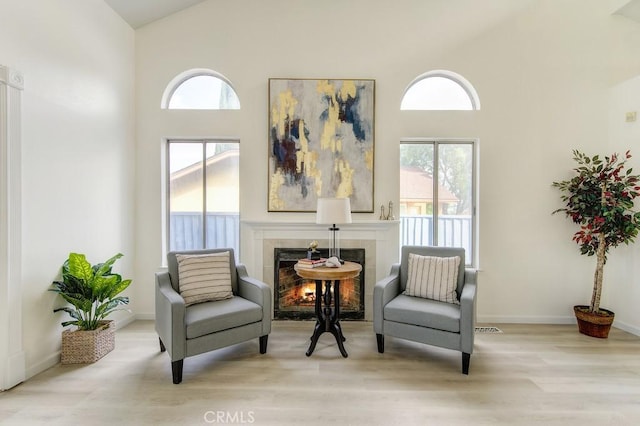 14 Fernwood Ct, Pittsburg, CA 94565 - sitting room with high vaulted ceiling, a tile fireplace, healthy amount of natural light, wood finished floors, and baseboards