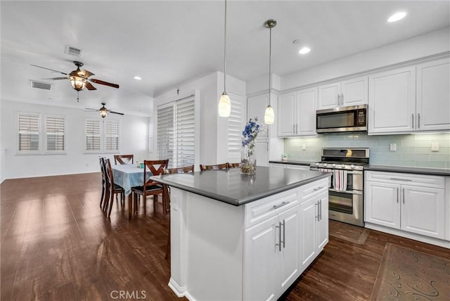 12473 Constellation St, Eastvale, CA 91752 - kitchen featuring stainless steel appliances, dark countertops, ceiling fan, dark wood-type flooring, and recessed lighting
