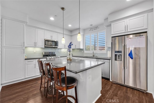 12473 Constellation St, Eastvale, CA 91752 - kitchen with stainless steel appliances, a sink, dark wood finished floors, white cabinetry, and recessed lighting